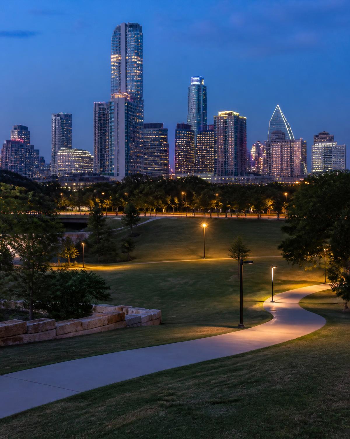 Texas city skyline at blue hour seen across a residential park